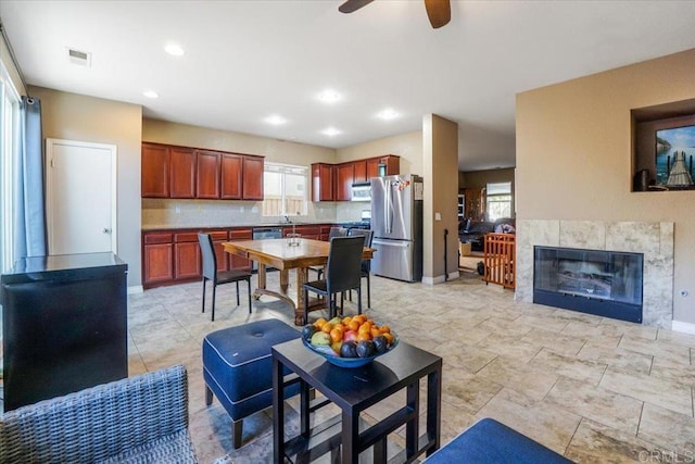 31616 Umbria Ln, Winchester, CA 92596 - kitchen with stainless steel appliances, plenty of natural light, a tile fireplace, and visible vents