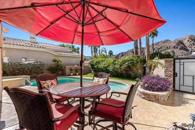 view of patio / terrace with a fenced in pool, a mountain view, and a storage shed