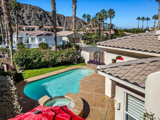 view of swimming pool featuring an in ground hot tub and a mountain view