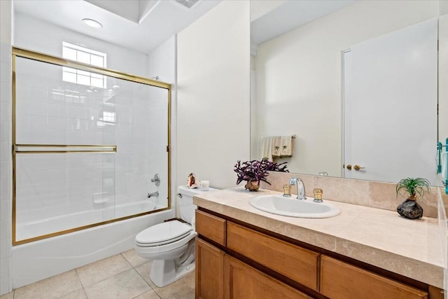 full bathroom with toilet, vanity, tile patterned floors, and bath / shower combo with glass door