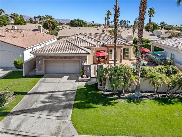 mediterranean / spanish house with a garage and a front lawn