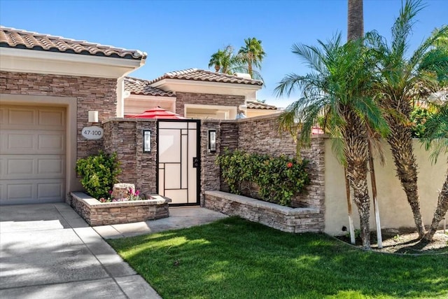 view of exterior entry featuring a yard and a garage