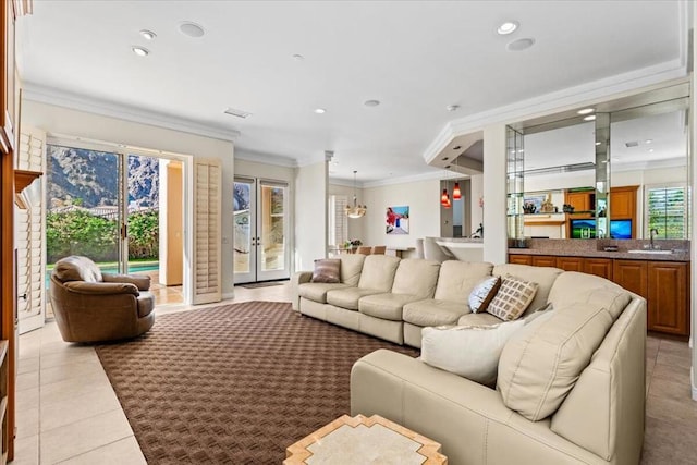 living room with ornamental molding, sink, and light tile patterned floors