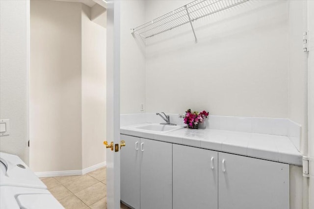 interior space featuring cabinets, light tile patterned floors, independent washer and dryer, and sink