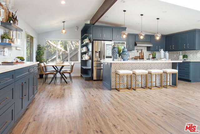 kitchen featuring decorative backsplash, light hardwood / wood-style floors, a breakfast bar area, and lofted ceiling with beams