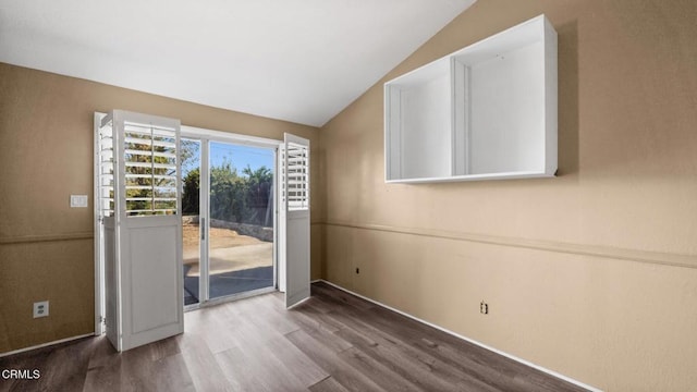 empty room featuring hardwood / wood-style flooring and lofted ceiling