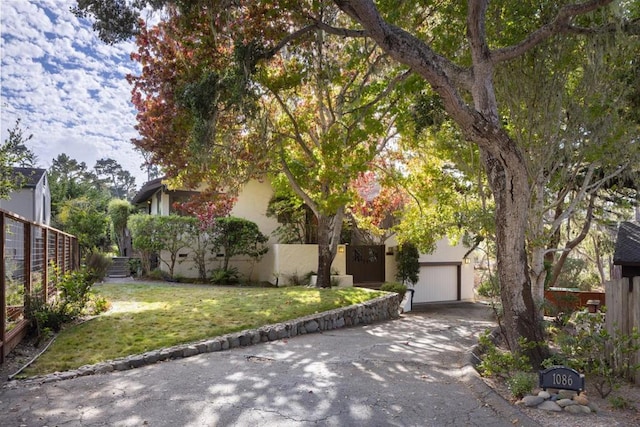 view of property hidden behind natural elements with a front lawn