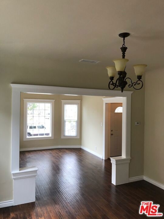 interior space with dark hardwood / wood-style floors and an inviting chandelier