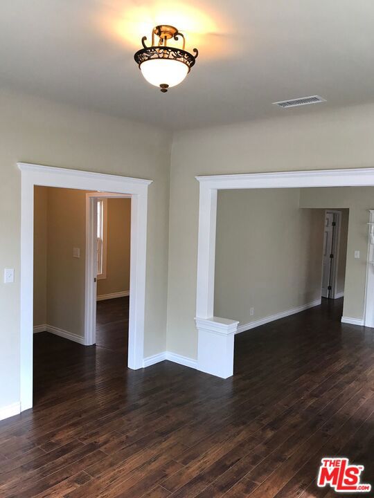 unfurnished room with dark hardwood / wood-style floors