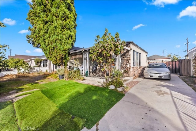 view of front of house featuring a front lawn and solar panels