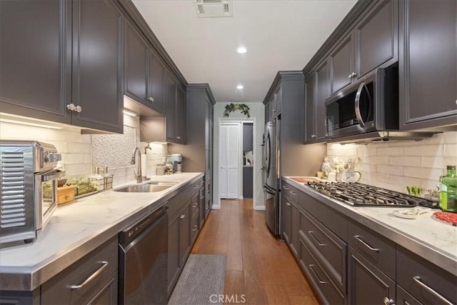 10409 Riverside Dr Unit 204, Toluca Lake, CA 91602 - kitchen with visible vents, dark wood finished floors, decorative backsplash, stainless steel appliances, and a sink