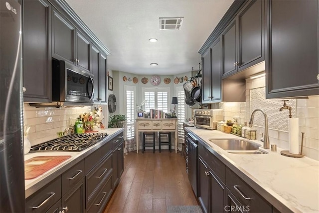 kitchen featuring decorative backsplash, stainless steel appliances, dark hardwood / wood-style floors, and sink