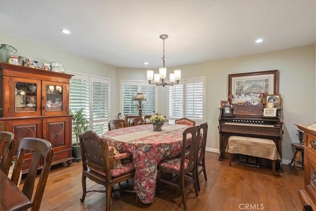 dining area featuring light hardwood / wood-style floors and a chandelier