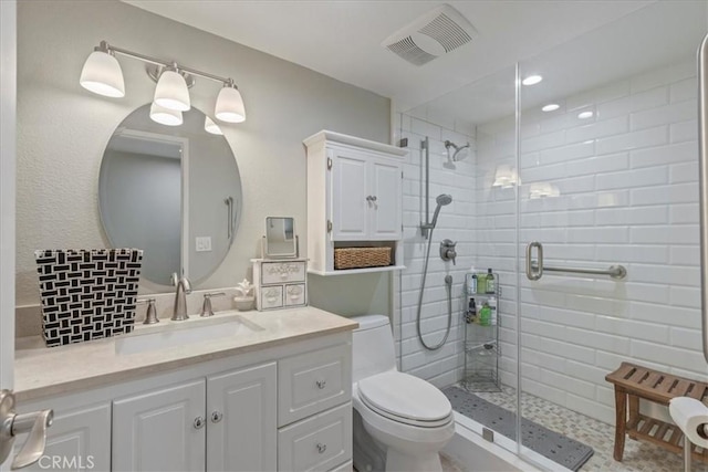 bathroom featuring vanity, an enclosed shower, and toilet