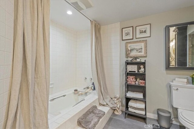 bathroom with shower / tub combo with curtain, tile patterned flooring, and toilet