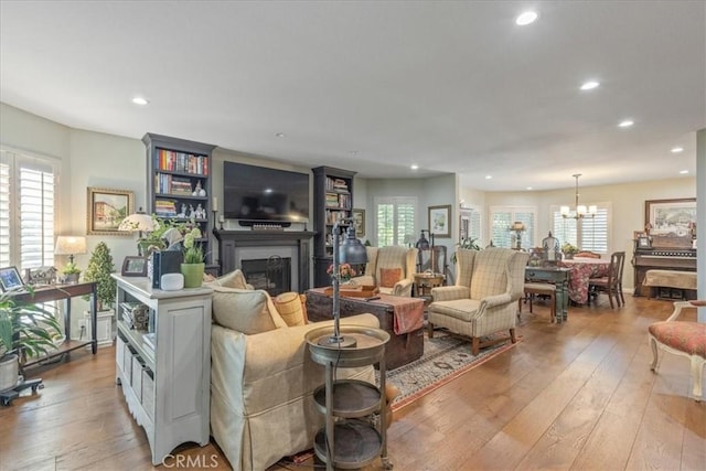 living room featuring light hardwood / wood-style floors, plenty of natural light, and a notable chandelier