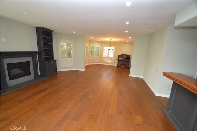 10409 Riverside Dr Unit 204, Toluca Lake, CA 91602 - unfurnished living room featuring baseboards, an inviting chandelier, a fireplace with flush hearth, recessed lighting, and hardwood / wood-style flooring