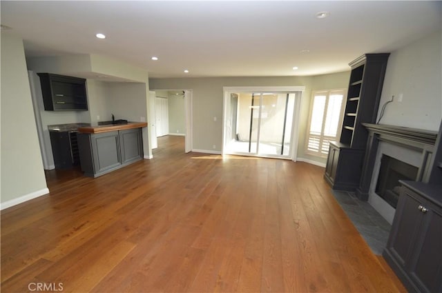 10409 Riverside Dr Unit 204, Toluca Lake, CA 91602 - unfurnished living room with recessed lighting, a fireplace with flush hearth, wood finished floors, and baseboards