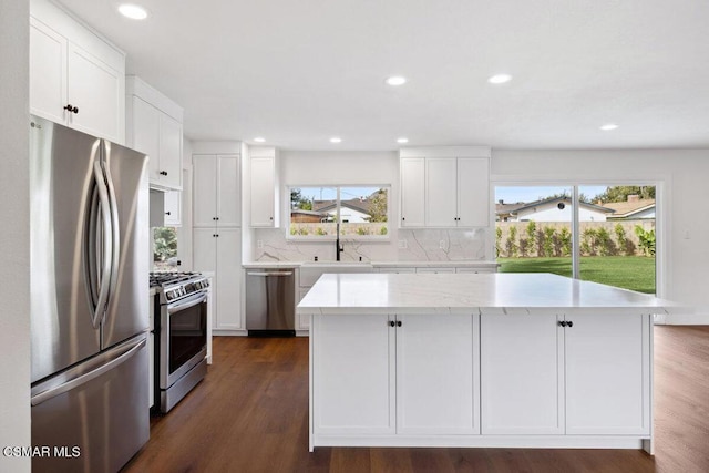 kitchen featuring white cabinetry, a center island, stainless steel appliances, and dark hardwood / wood-style floors