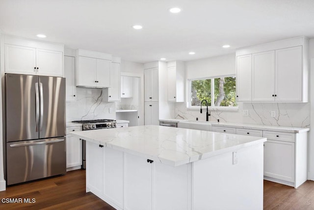 kitchen featuring white cabinets, appliances with stainless steel finishes, a kitchen island, and sink