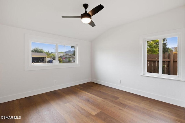 spare room featuring hardwood / wood-style flooring, vaulted ceiling, a wealth of natural light, and ceiling fan