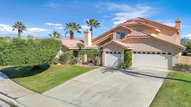 mediterranean / spanish house featuring a front yard and a garage