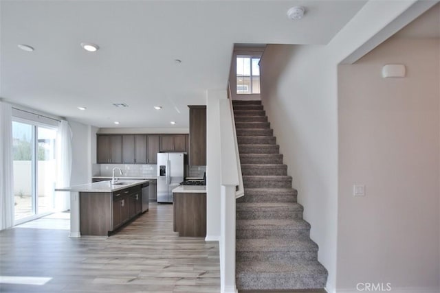 stairs featuring hardwood / wood-style flooring and sink