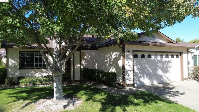 view of front of home with a front yard and a garage