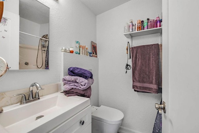 bathroom with vanity, a textured ceiling, and toilet