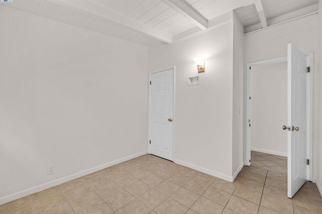 spare room with beam ceiling, light tile patterned flooring, and wood ceiling