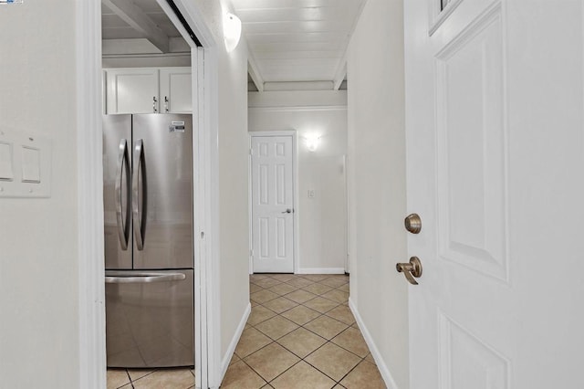 kitchen featuring white cabinets, light tile patterned floors, and stainless steel refrigerator