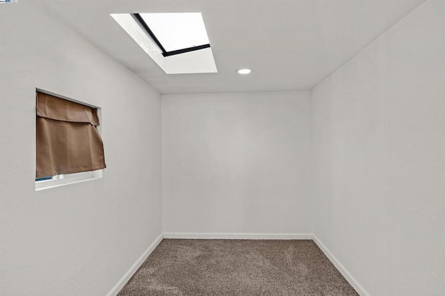 carpeted empty room with a skylight