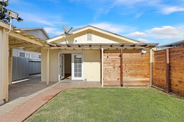 back of property with a patio and a lawn