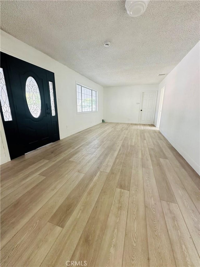 entryway with a textured ceiling and light hardwood / wood-style flooring