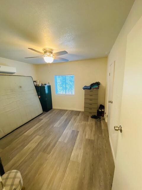 unfurnished bedroom with ceiling fan, a textured ceiling, and hardwood / wood-style flooring