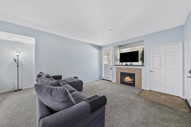 living room with carpet and a tiled fireplace