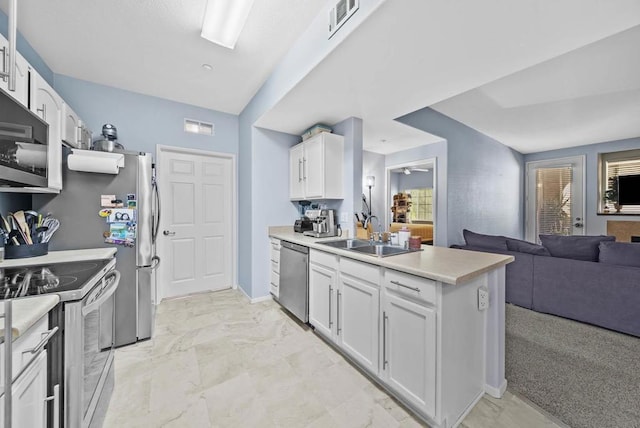 kitchen featuring sink, white cabinets, stainless steel appliances, and light colored carpet