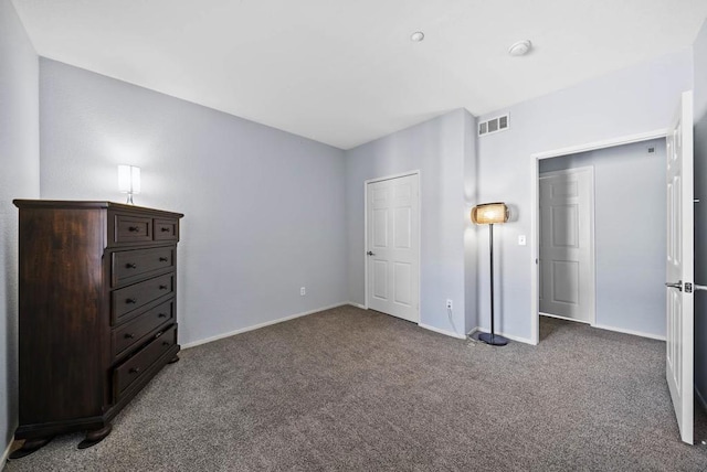 unfurnished bedroom featuring dark carpet and a closet