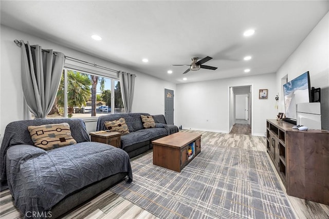 living room featuring ceiling fan and light hardwood / wood-style flooring