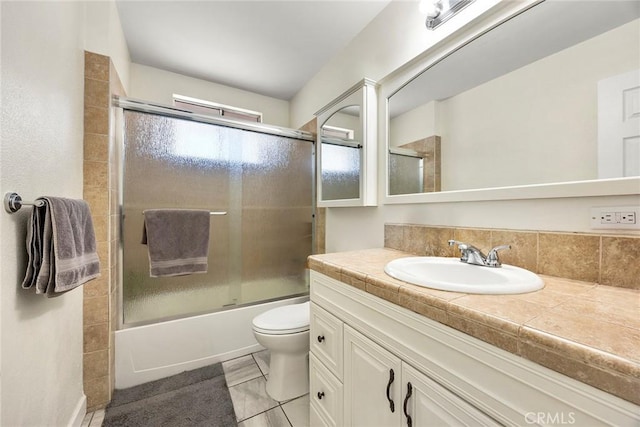 full bathroom with tile patterned flooring, vanity, toilet, and bath / shower combo with glass door