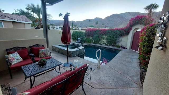 view of pool featuring a mountain view, an outdoor living space, a patio, and an in ground hot tub