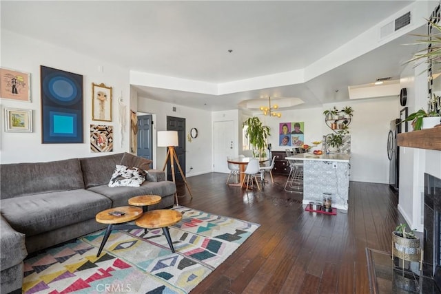 living room featuring a high end fireplace, dark hardwood / wood-style floors, and an inviting chandelier