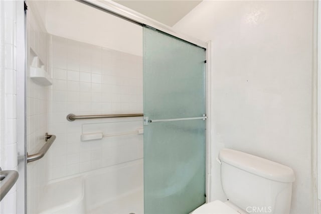 bathroom featuring toilet and an enclosed shower