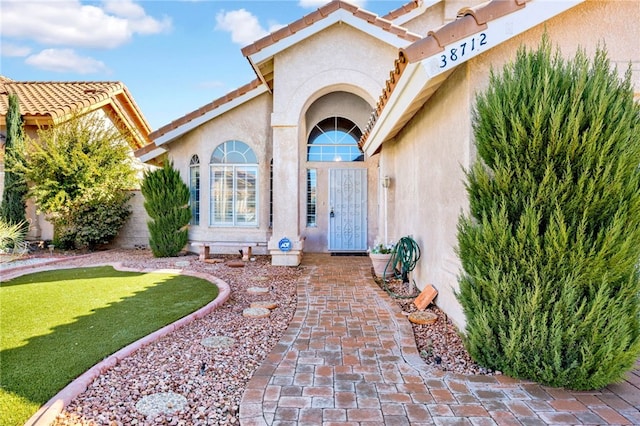 view of exterior entry with a lawn