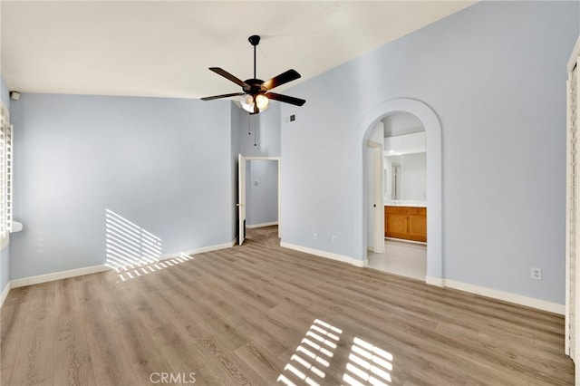 empty room with ceiling fan, light hardwood / wood-style flooring, and lofted ceiling