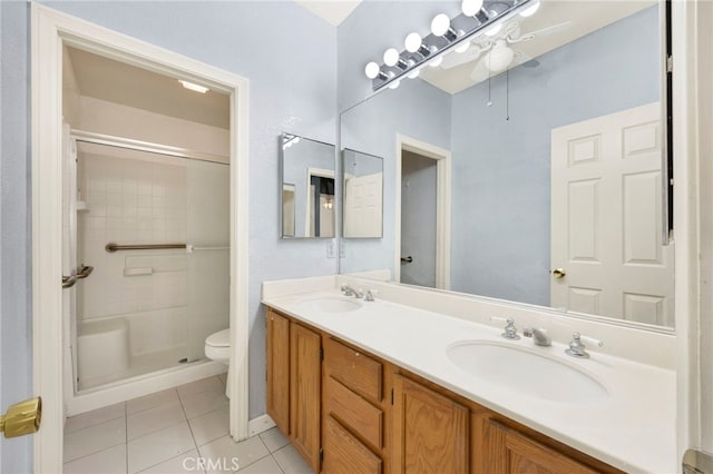 bathroom with vanity, tile patterned flooring, ceiling fan, toilet, and tiled shower