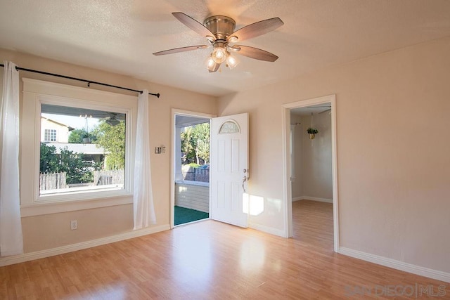 entryway featuring a textured ceiling, light hardwood / wood-style floors, and ceiling fan