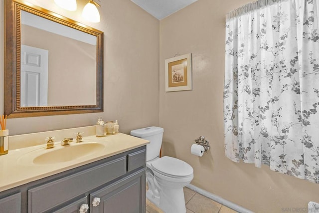 bathroom with tile patterned flooring, vanity, and toilet