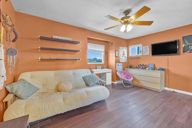 living room with a textured ceiling, dark hardwood / wood-style floors, and ceiling fan