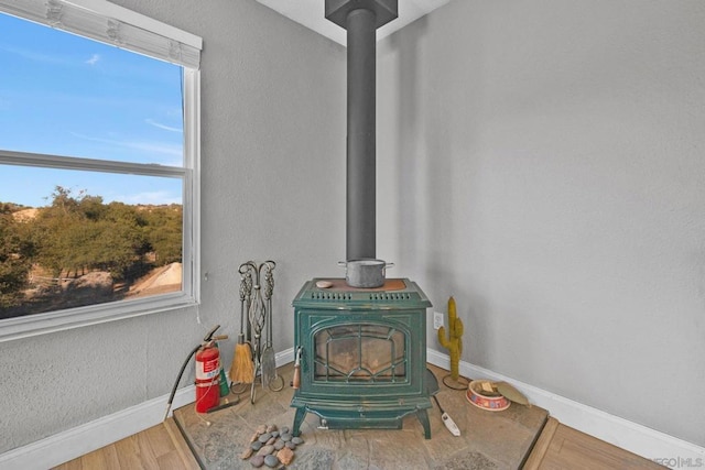 interior details with hardwood / wood-style flooring and a wood stove